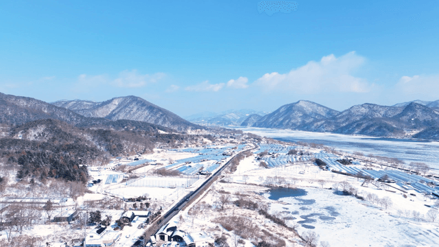 눈에 덮힌 산을 배경으로 한 비닐하우스 농촌 지역