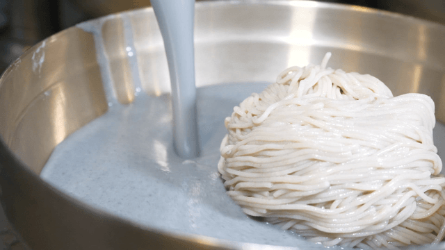 Black bean broth poured onto buckwheat noodles