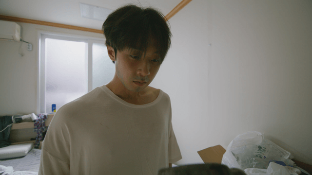 Young man holding a hammer in a messy room
