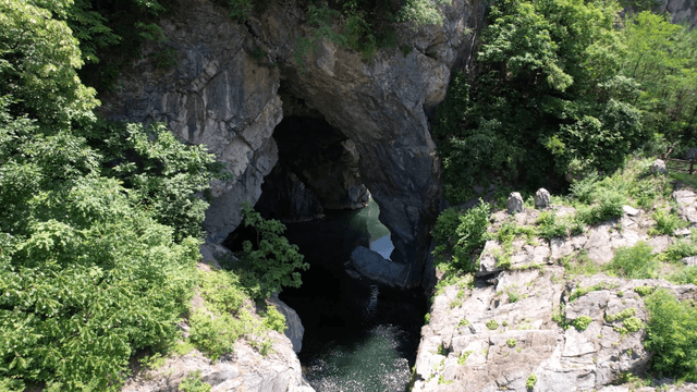 Valley water flowing through dark rocky cave