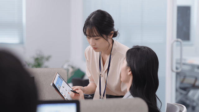 Two colleagues discussing work at a desk