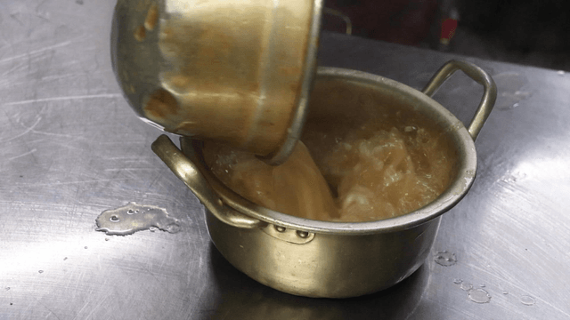 Broth poured over chicken noodle soup