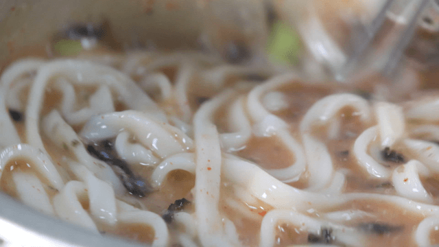 Chicken noodle soup stirred in a pot