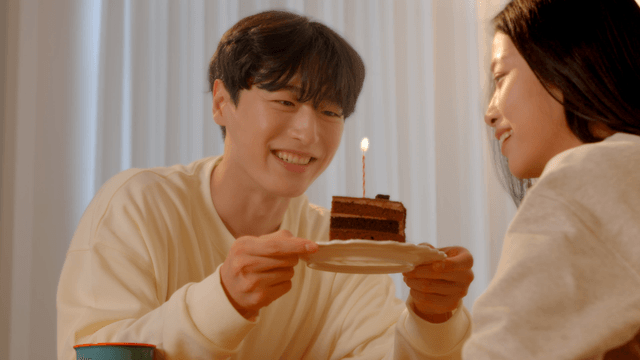 Couple happily celebrating while blowing cake candles