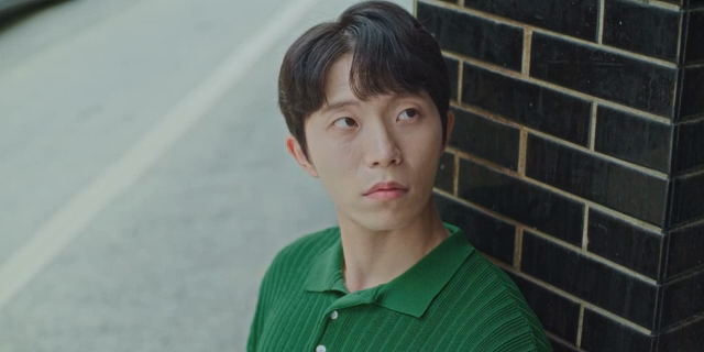 남자가 벽돌 벽에 기대어 있는 모습