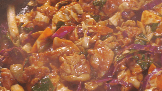 Spicy stir-fried chicken being cooked