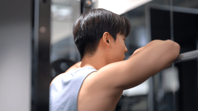 Man resting against barbell during workout