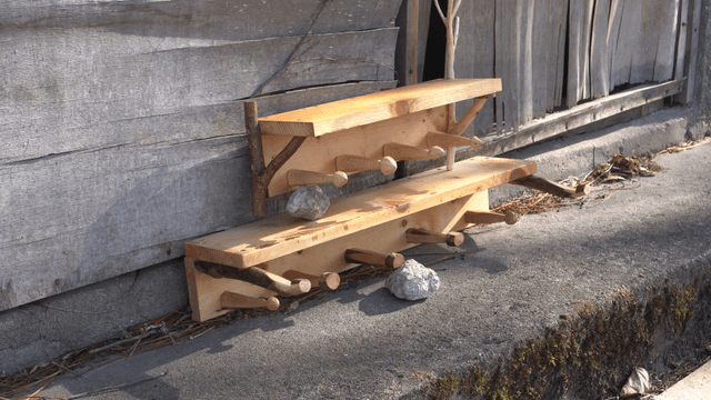 Wooden shelves leaning against an old wooden wall