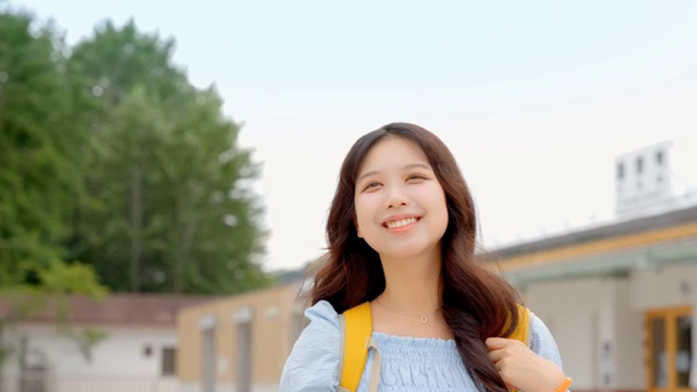 야외에서 웃으며 손을 흔드는 젊은 여성