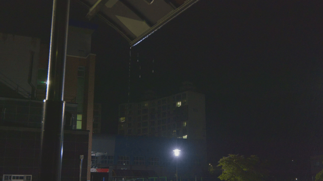 Rain falling over a school with apartment view