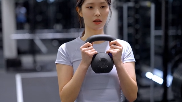 Young woman doing kettlebell squat exercise