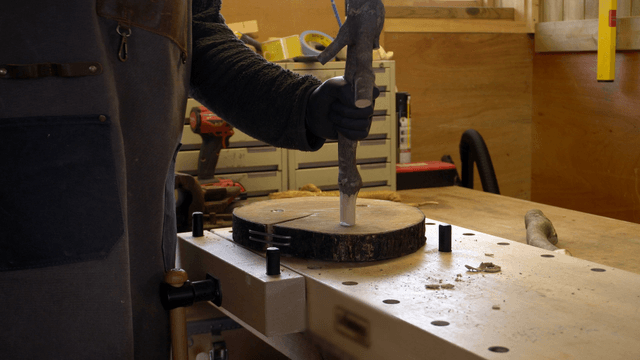 Artisan assembling wooden branches onto a board on worktable