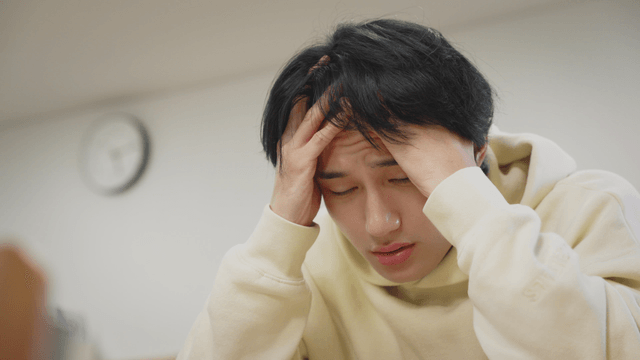 머리를 감싸며 스트레스를 받는 남성