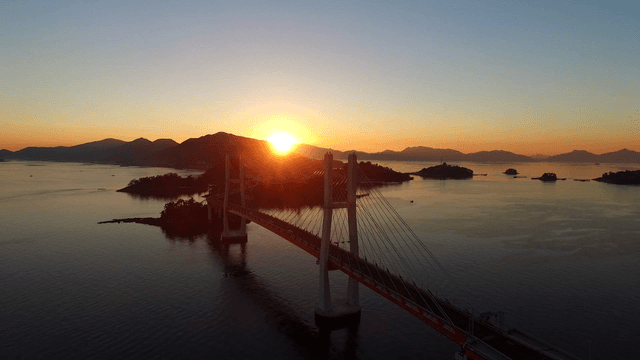 Sunrise over a bridge and calm sea