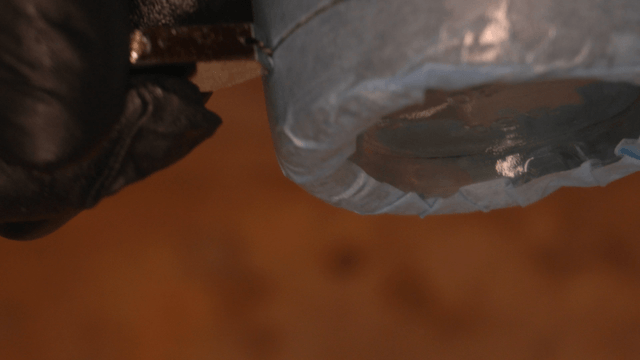 Hand cutting a glass bottle with masking tape