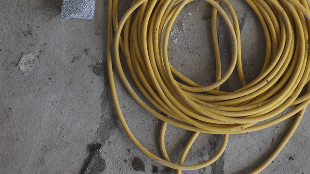 Yellow cable coiled on a concrete floor