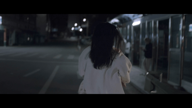 Woman running through a dimly lit street