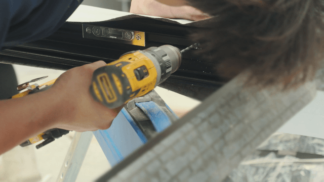 Person using a drill on a metal frame