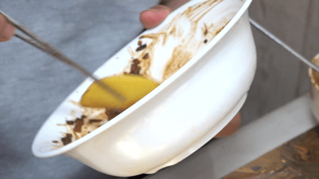 Person scooping up black bean sauce with pickled radish