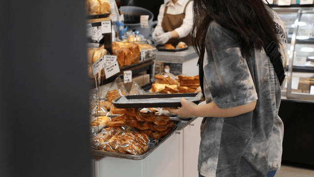 Person selecting pastries in a bakery