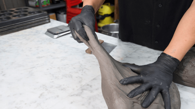 Baker portioning dough on marble counter