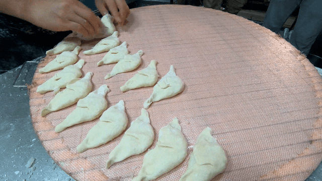 쟁반 위 빠르게 빚어지는 만두들
