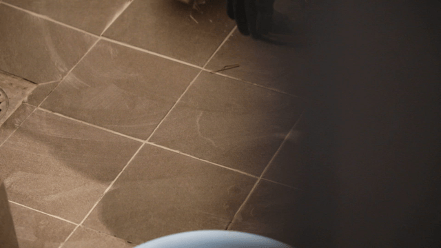 Worker cleaning tiles in a bathroom