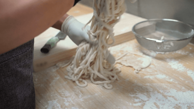 Handmade noodles being prepared on a board