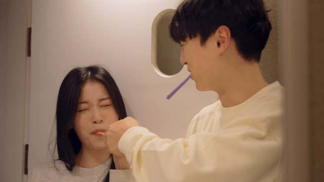 Couple playfully brushing teeth together