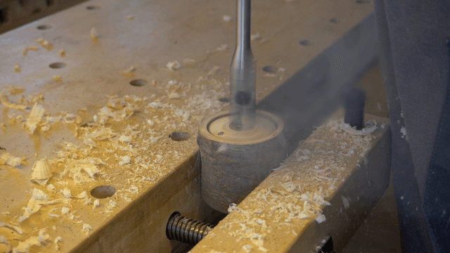Drilling holes in wood with an electric drill on a workbench