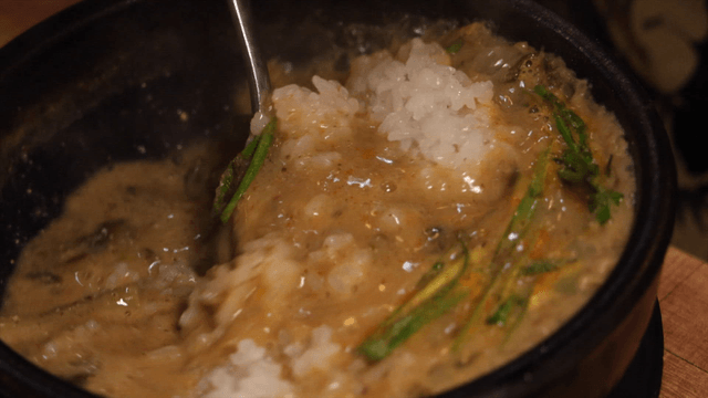 Loach soup boiling as rice is stirred