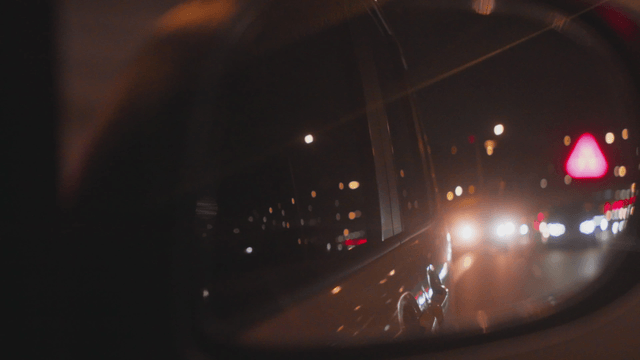 Night road view reflected in a side mirror