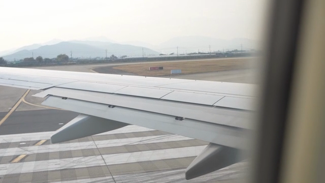 활주로에서 택시 중인 비행기 날개