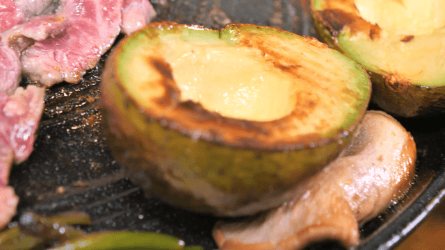 Grilling avocado and mushrooms on a pan