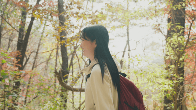 Young woman on autumn trail under sunlight