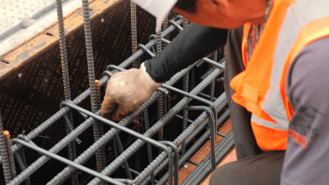 Worker assembling rebar at a construction site