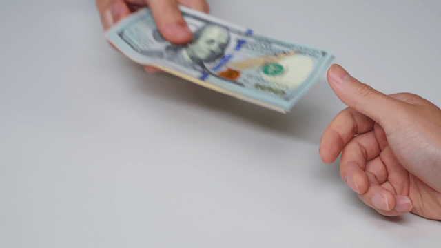 Hands exchanging currency bills