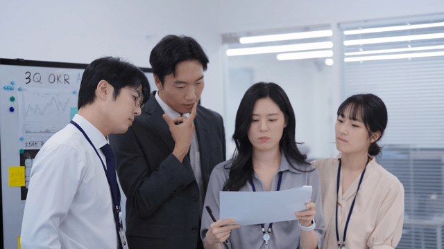 Team members standing and seriously reviewing meeting documents