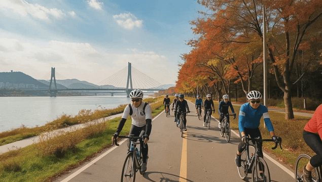People cycling along riverside path in autumn