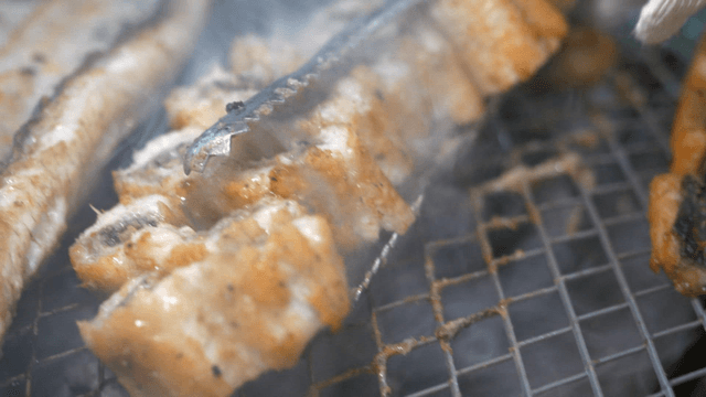 Eels evenly grilled on charcoal grate