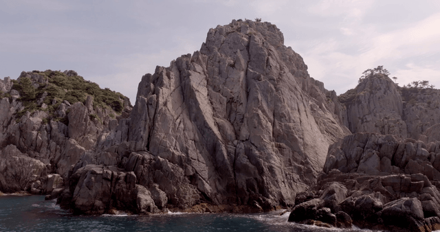 Rocky cliffs by the sea under a cloudy sky