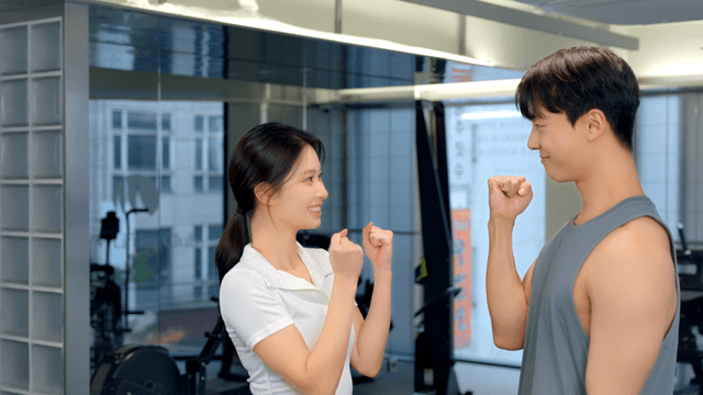 Couple high-fiving with a smile at the gym