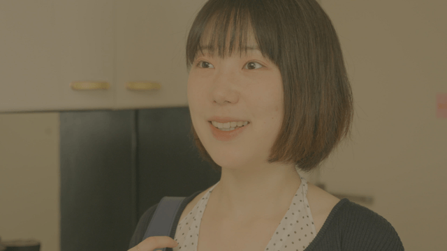 Woman with bob hair greeting with smile at entrance