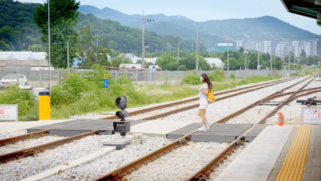A young woman walking on a train platform