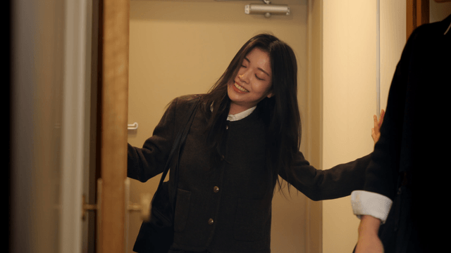 Couple entering home with bright smiles