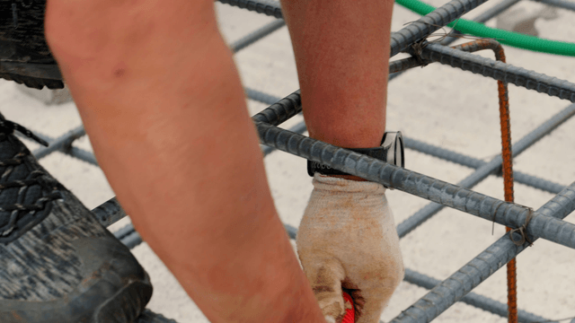 Worker handling rebar at a construction site