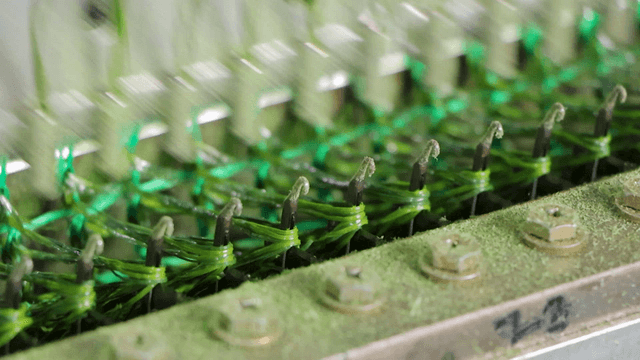 Textile machine rapidly weaving green threads