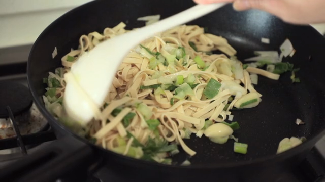 Noodles being stir-fried with vegetables