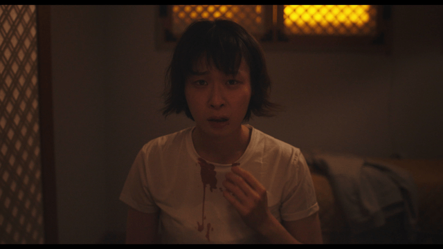 Woman in bloodstained shirt agonizing
