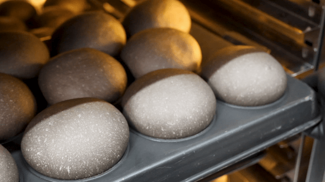 제빵 트레이 위 오븐에서 꺼내지는 검은 빵